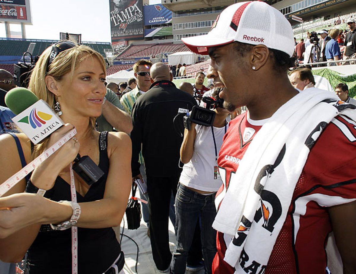 Ines Sainz measures  wide receiver Steve Breaston's bicep