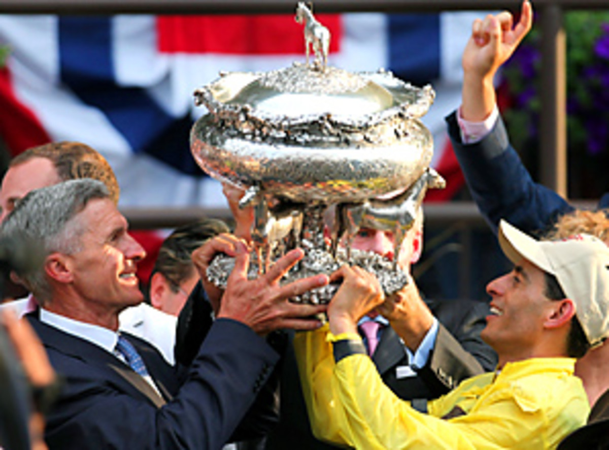 Union Rags trainer Michael Matz and jockey John Velazquez display the trophy in the winners circle after Saturday's Belmont Stakes.