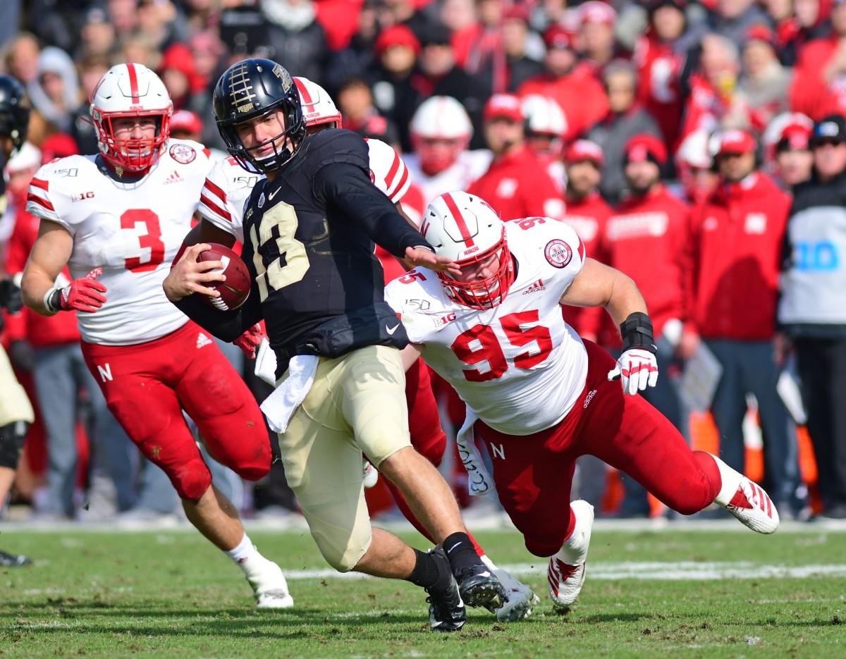 West Lafayette, IN, USA; Purdue Boilermakers quarterback Jack Plummer (13) is pursued by Nebraska Cornhuskers defensive lineman Ben Stiller (95) in the first half at Ross-Ade Stadium. Mandatory Credit: Thomas J. Russo-USA TODAY Sports