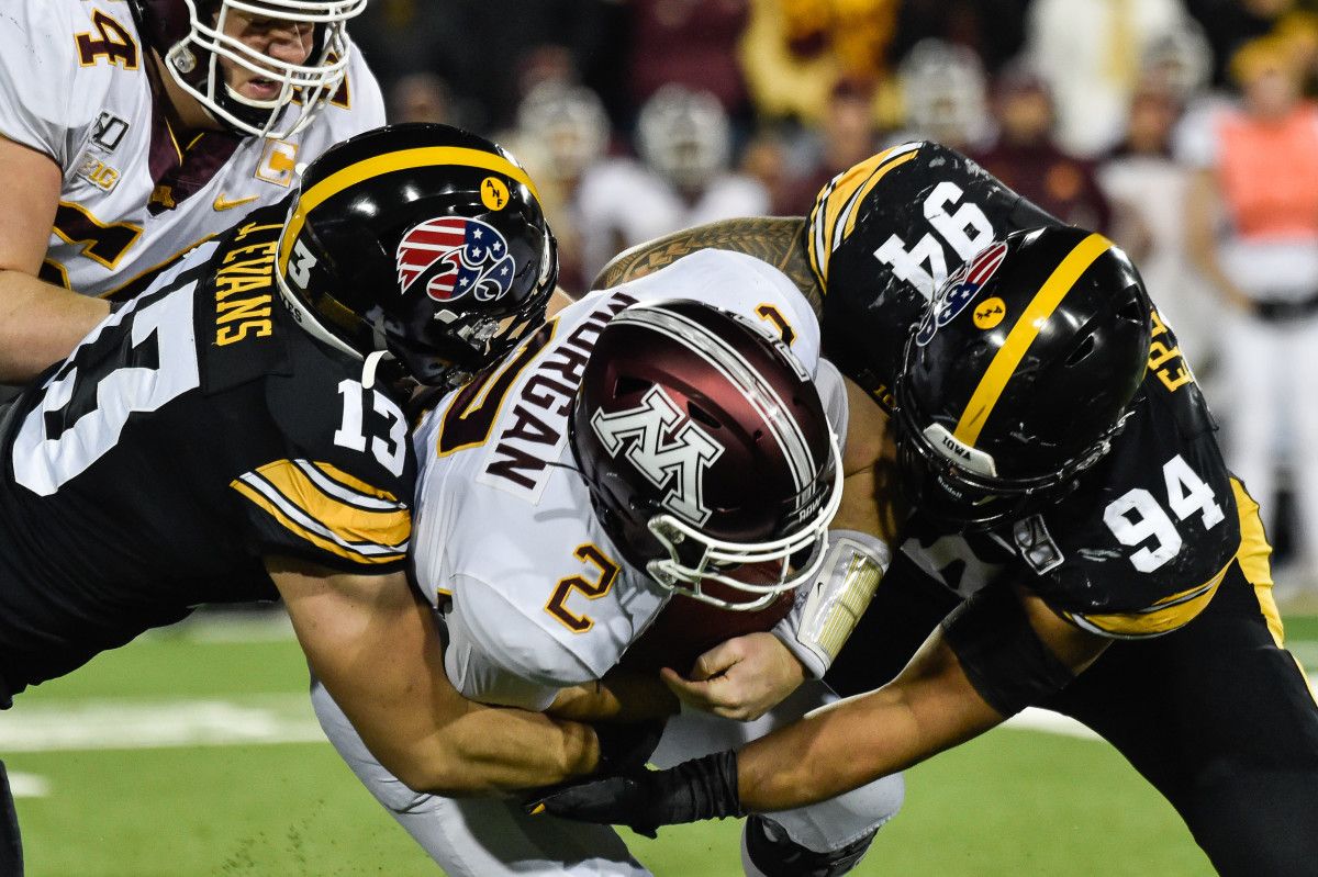 Minnesota quarterback Tanner Morgan (2) is sacked by Iowa defensive end A.J. Epenesa (94) and defensive end Joe Evans (13) during the fourth quarter at Kinnick Stadium.