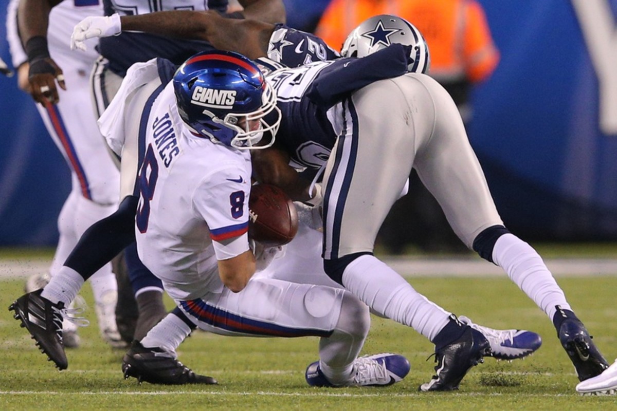 Nov 4, 2019; East Rutherford, NJ, USA; New York Giants quarterback Daniel Jones (8) fumbles as he's hit by Dallas Cowboys safety Xavier Woods (25) during the third quarter at MetLife Stadium.