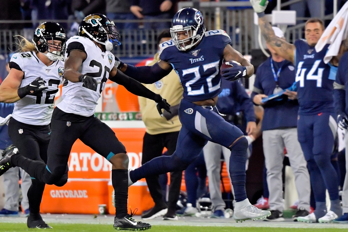 Tennessee Titans running back Derrick Henry (22) rushes past Jacksonville Jaguars free safety Jarrod Wilson (26) to score a touchdown during the second half at Nissan Stadium.