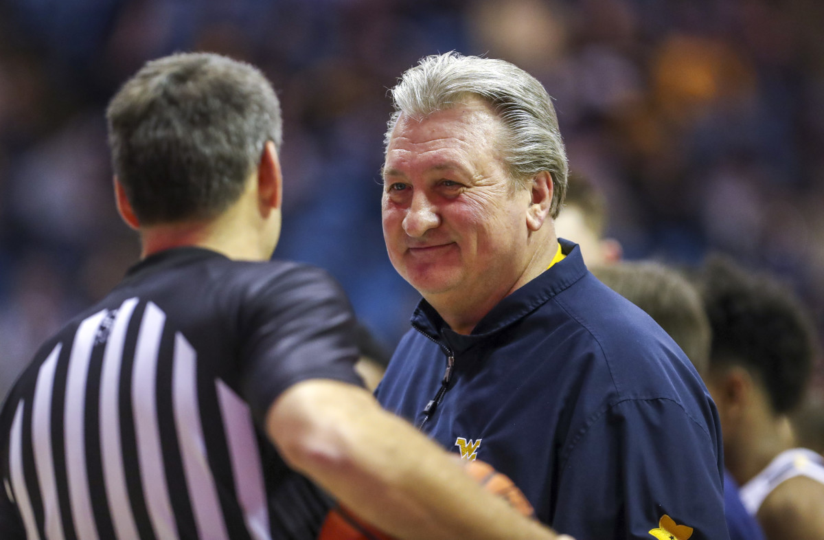 West Virginia Mountaineers head coach Bob Huggins smiles while talking to an official during the second half against the Boston University Terriers at WVU Coliseum.