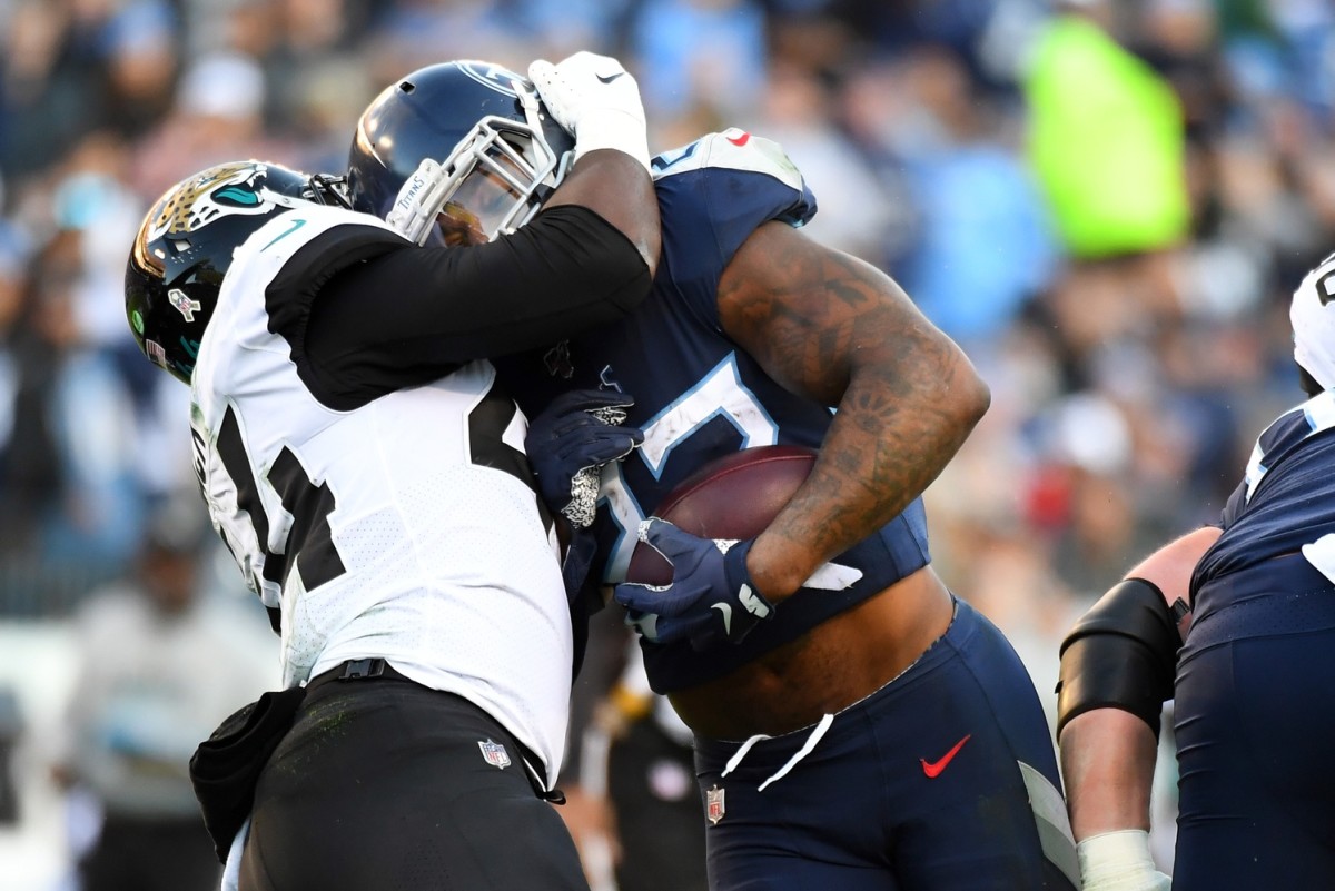 Tennessee Titans running back Derrick Henry (22) pushes forward against Jacksonville Jaguars middle linebacker Myles Jack (44) for a first down during the first half at Nissan Stadium.