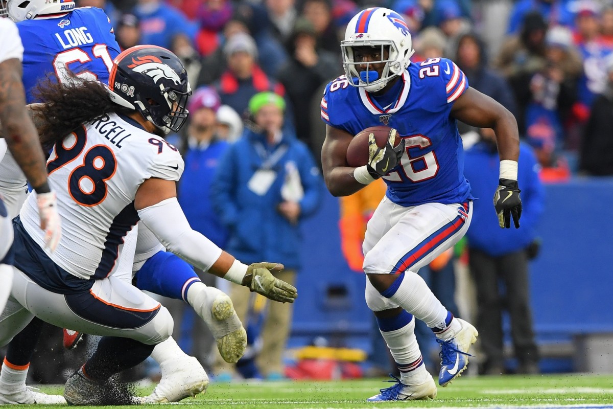 Buffalo Bills running back Devin Singletary (26) runs with the ball as Denver Broncos nose tackle Mike Purcell (98) defends during the third quarter at New Era Field.