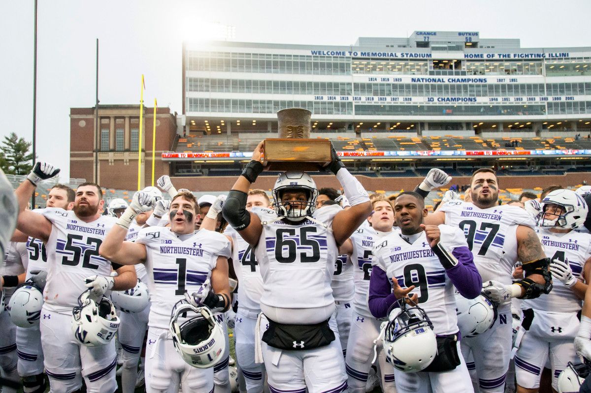 The Northwestern Wildcats celebrate with the Land of Lincoln Trophy after defeating the Illinois Fighting Illini at Memorial Stadium.