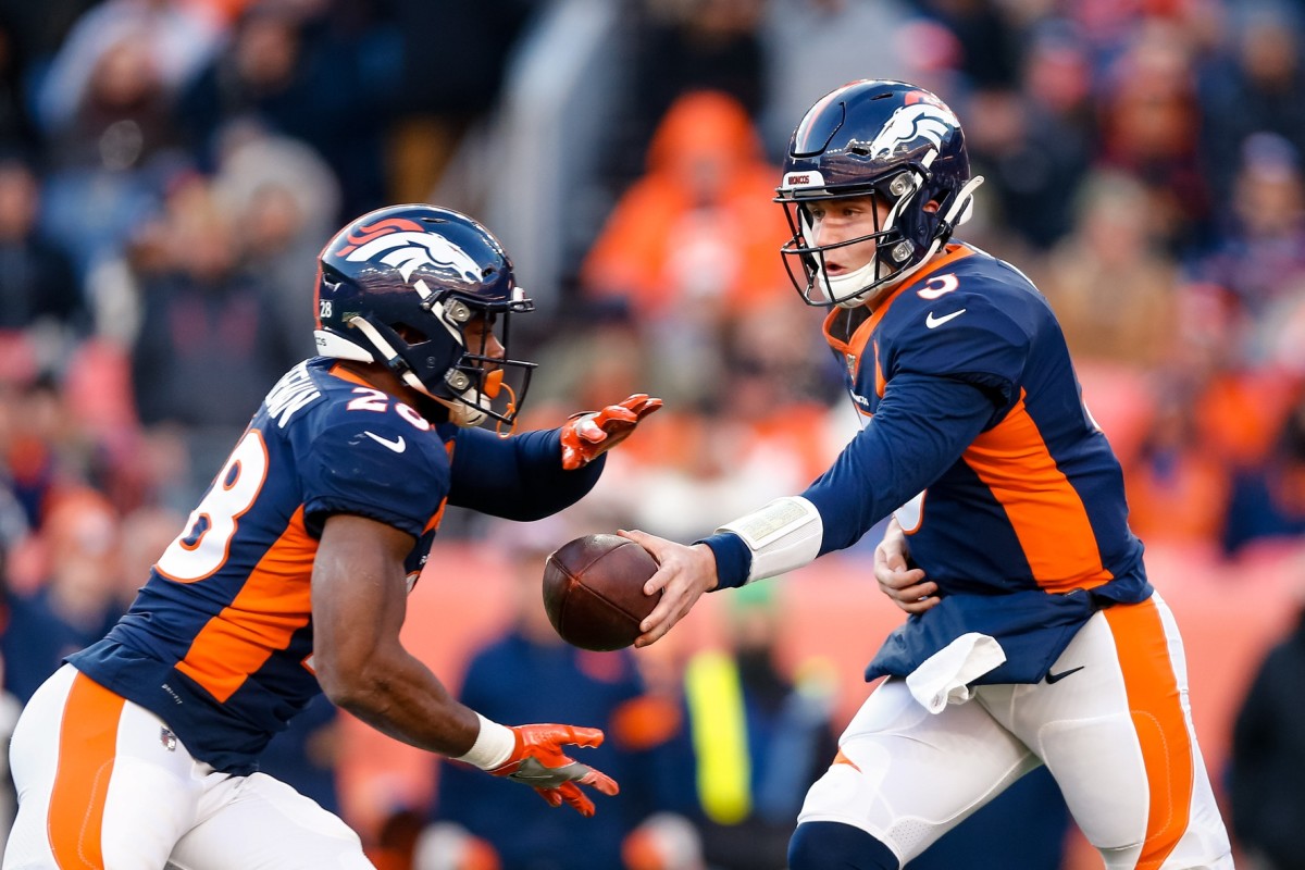 Denver Broncos quarterback Drew Lock (3) hands the ball off to running back Royce Freeman (28) in the second quarter against the Los Angeles Chargers at Empower Field at Mile High.