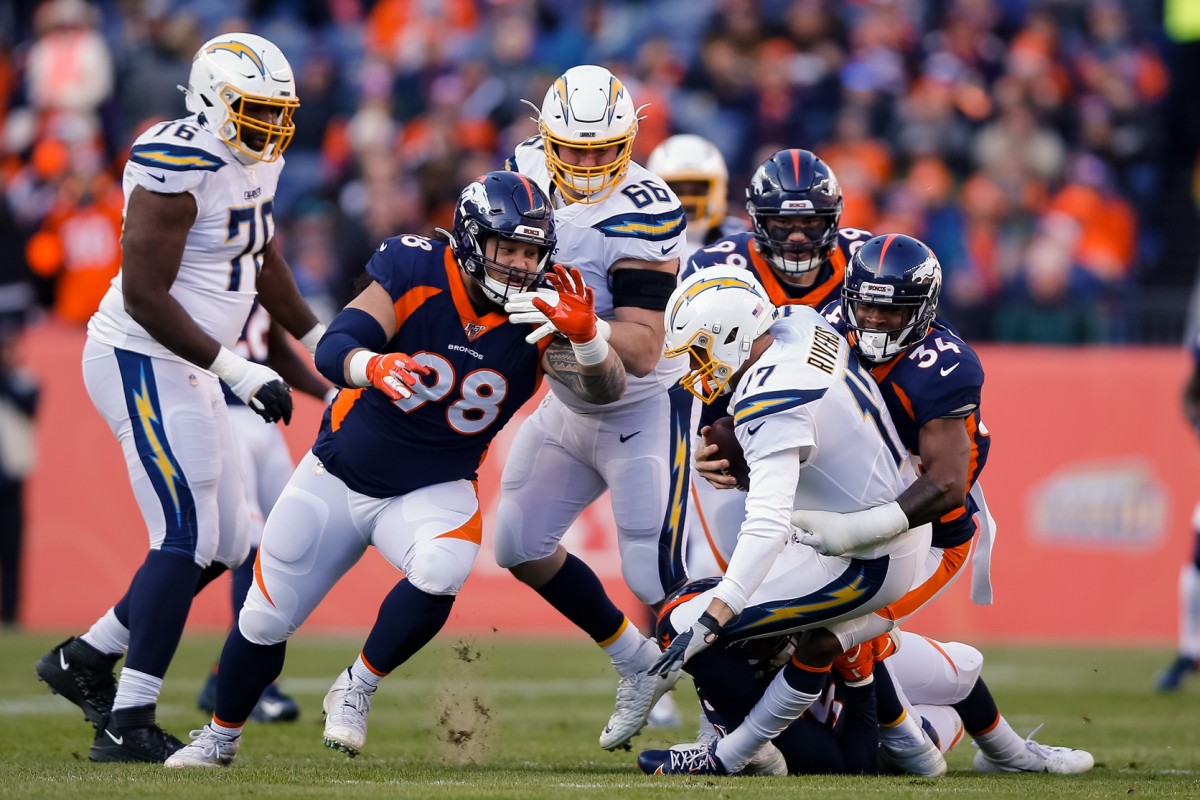 Los Angeles Chargers quarterback Philip Rivers (17) is sacked by Denver Broncos strong safety Will Parks (34) as nose tackle Mike Purcell (98) and defensive end Adam Gotsis (99) defend while offensive tackle Russell Okung (76) and offensive guard Dan Feeney (66) look on in the first quarter at Empower Field at Mile High.