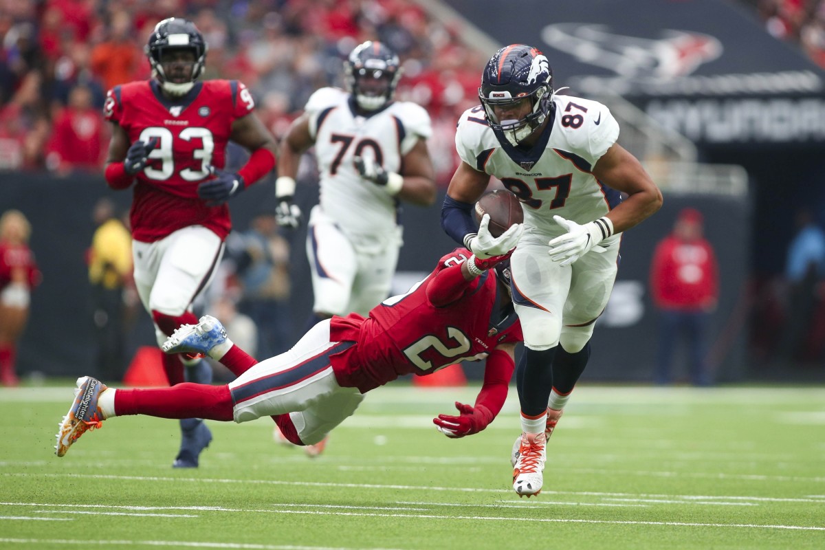 Denver Broncos tight end Noah Fant (87) runs after a reception while Houston Texans strong safety Justin Reid (20) reaches to make a tackle during the second quarter at NRG Stadium.
