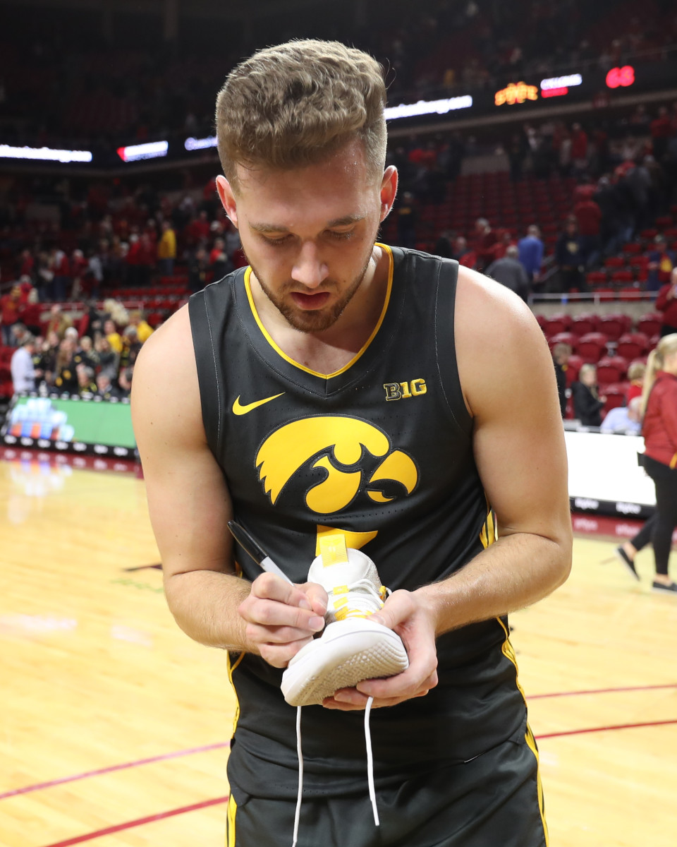 Jordan Bohannon signs his shoes as he leaves the Hilton Coliseum court after Thursday's win over Iowa State. (Reese Strickland/USA Today Sports)