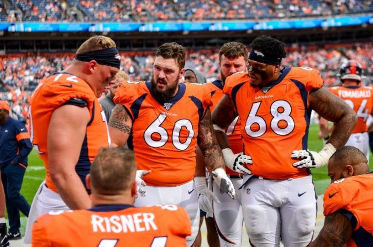 Connor McGovern #60 of the Denver Broncos talks to teammates on the offensive line, including Garett Bolles #72, Elijah Wilkinson #68, and Dalton Risner #66 as they sit in the bench area during a game against the Chicago Bears at Empower Field at Mile High on September 15, 2019 in Denver, Colorado.