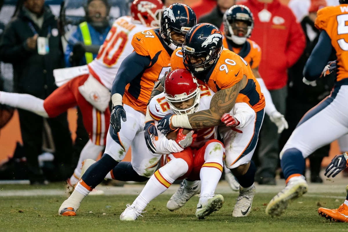Kansas City Chiefs wide receiver Albert Wilson (12) is tackled by Denver Broncos nose tackle Kyle Peko (90) in the third quarter at Sports Authority Field at Mile High.