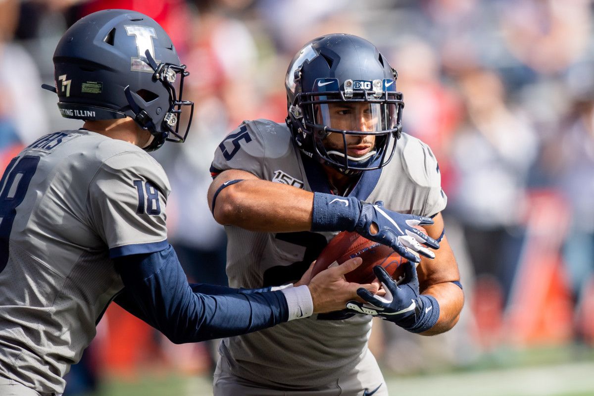 Illinois quarterback Brandon Peters (18) hands the ball off to running back Dre Brown (25) during a game against the Wisconsin Badgers at Memorial Stadium.