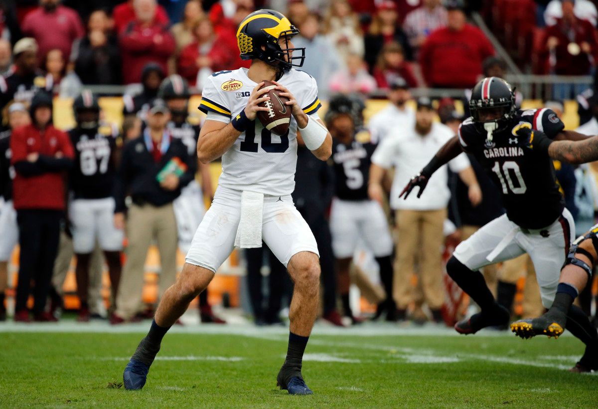 Michigan quarterback Brandon Peters (18) drops back against the South Carolina Gamecocks during the first quarter of the 2018 Outback Bowl at Raymond James Stadium.