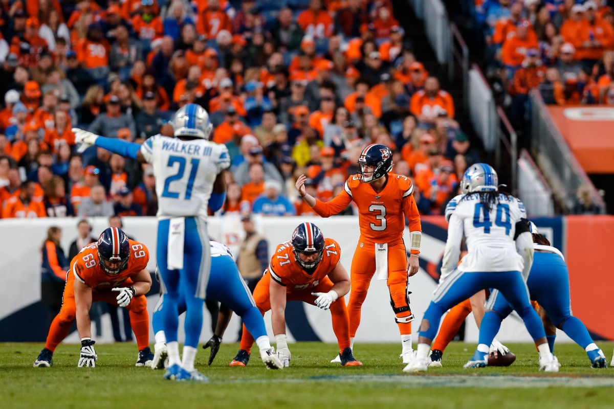 Denver Broncos quarterback Drew Lock (3) motions at the line of scrimmage behind offensive guard Austin Schlottmann (71) and offensive tackle Jake Rodgers (69) as Detroit Lions linebacker Jalen Reeves-Maybin (44) and free safety Tracy Walker (21) look on in the fourth quarter at Empower Field at Mile High.