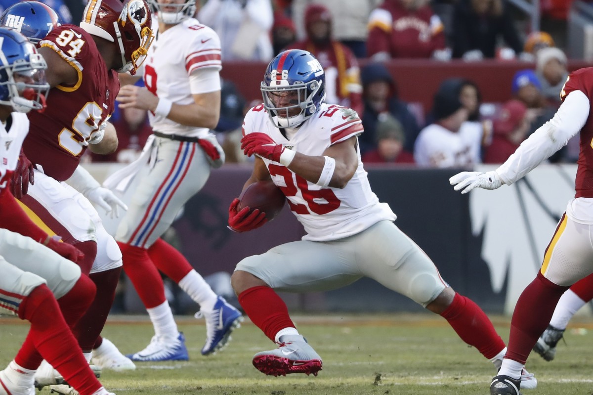 Dec 22, 2019; Landover, Maryland, USA; New York Giants running back Saquon Barkley (26) carries the ball past Washington Redskins nose tackle Daron Payne (94) in the second quarter at FedEx Field.