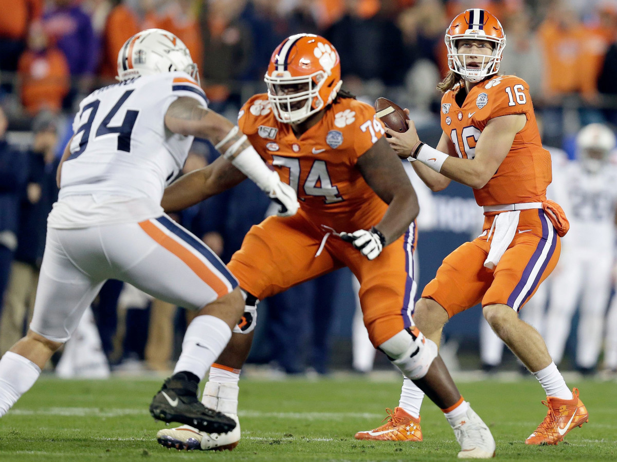 Clemson quarterback Trevor Lawrence (16) looks to pass while offensive lineman John Simpson (74) blocks Virginia defensive tackle Aaron Faumui (94) duriung the first half of the Atlantic Coast Conference championship NCAA college football game in Charlotte, N.C