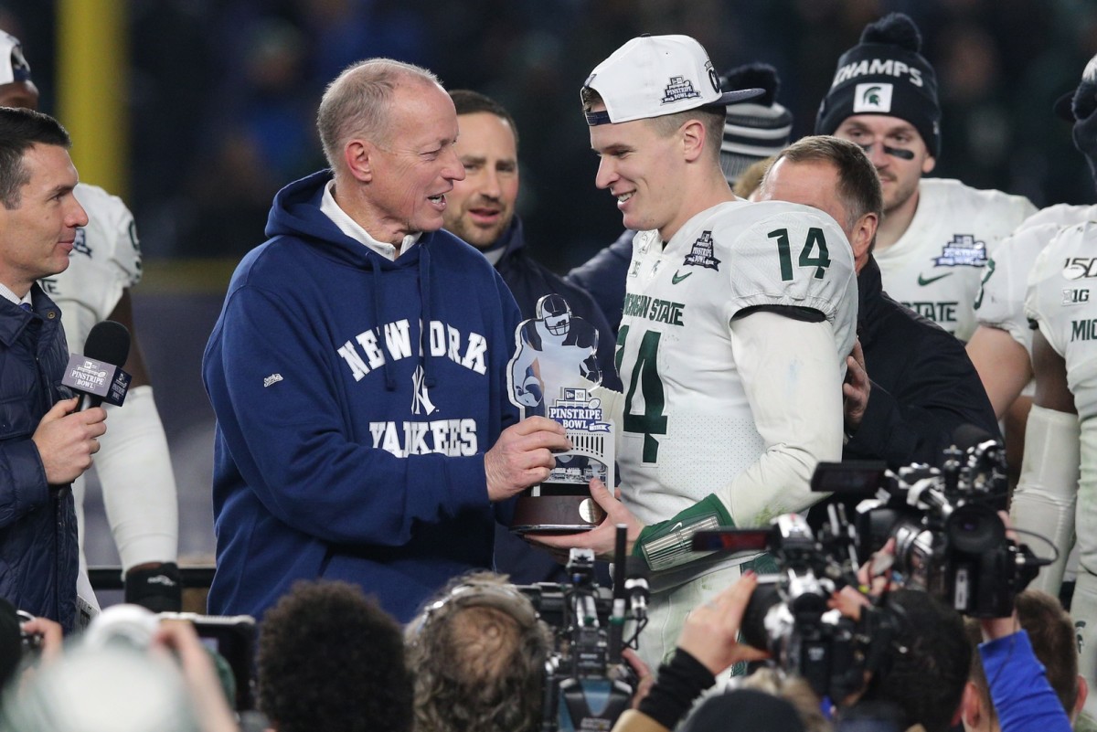 Michigan State quarterback Brian Lewerke accepts the Pinstripe Bowl trophy from former Buffalo Bills great Jim Kelly after the Spartans beat Wake Forest on Friday. (Mandatory credit: USA TODAY SPORTS)