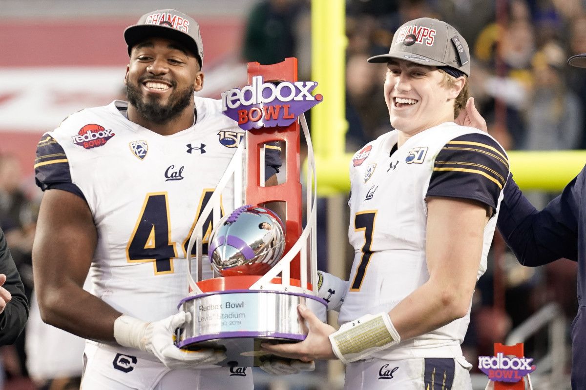 California Golden Bears defensive end Zeandae Johnson (44) and quarterback Chase Garbers (7) hold the RedBox trophy after defeating the Illinois Fighting Illini at Levi's Stadium