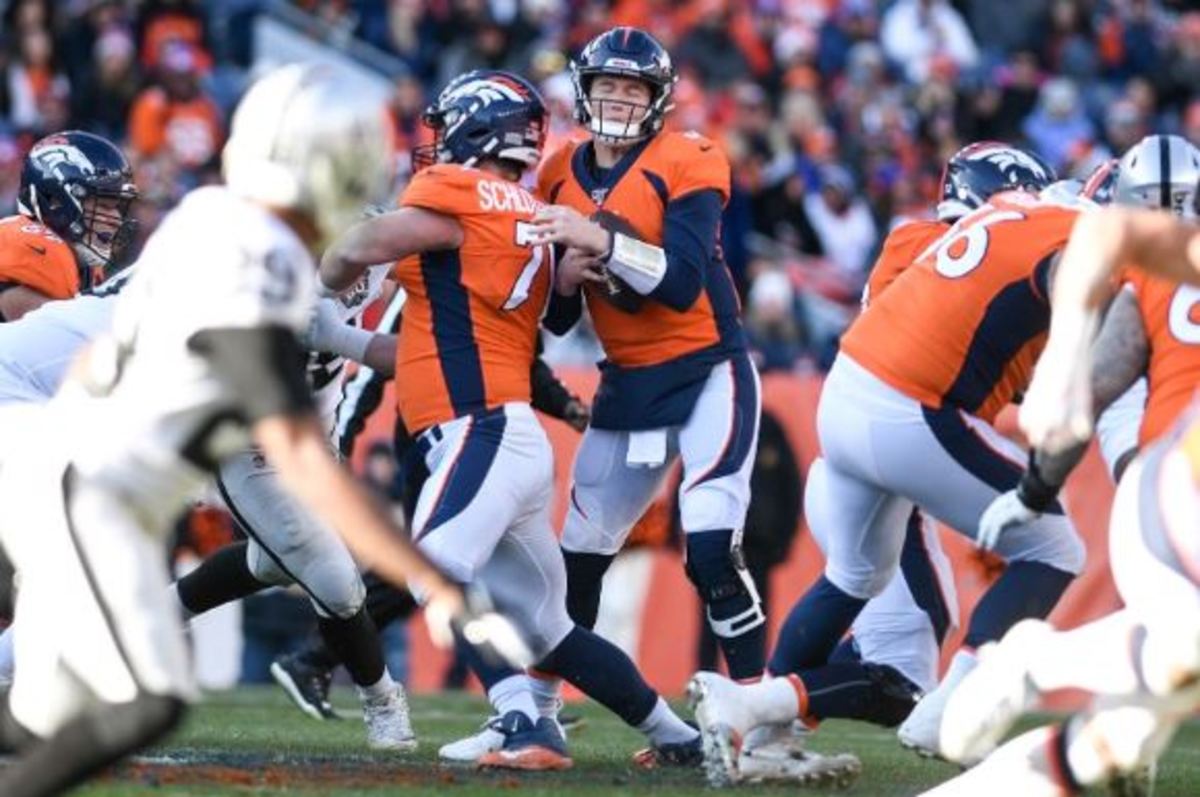 Drew Lock (3) of the Denver Broncos runs into Austin Schlottmann (71) before falling to the ground for a loss against the Oakland Raiders during the first quarter on Sunday, December 28, 2019.