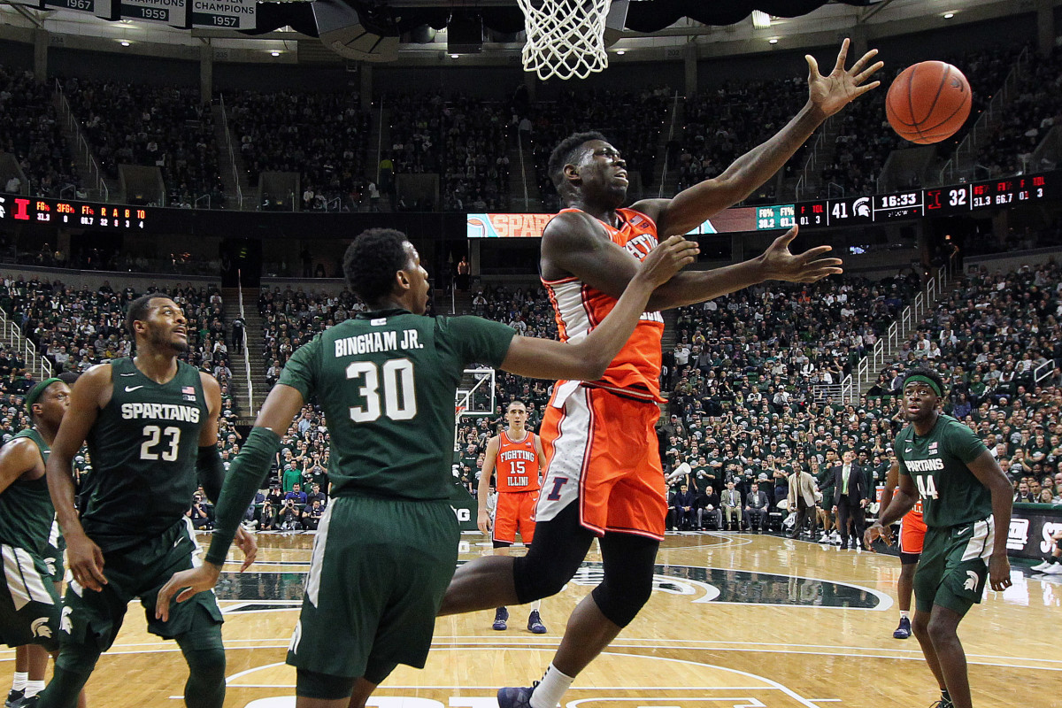 Illinois center Kofi Cockburn (21) and Michigan State forward Marcus Bingham Jr. (30) fight for a loose ball during the second half of a game at the Breslin Center.