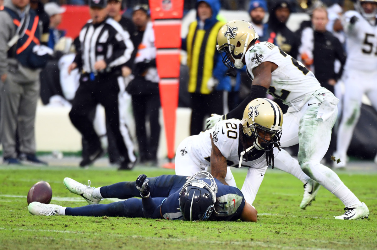 Dec 22, 2019; Nashville, Tennessee, USA; Tennessee Titans wide receiver Kalif Raymond (14) lays on the field after being hit by New Orleans Saints cornerback Janoris Jenkins (20) and fumbling the ball on a play during the second half at Nissan Stadium. Mandatory Credit: Christopher Hanewinckel-USA TODAY Sports