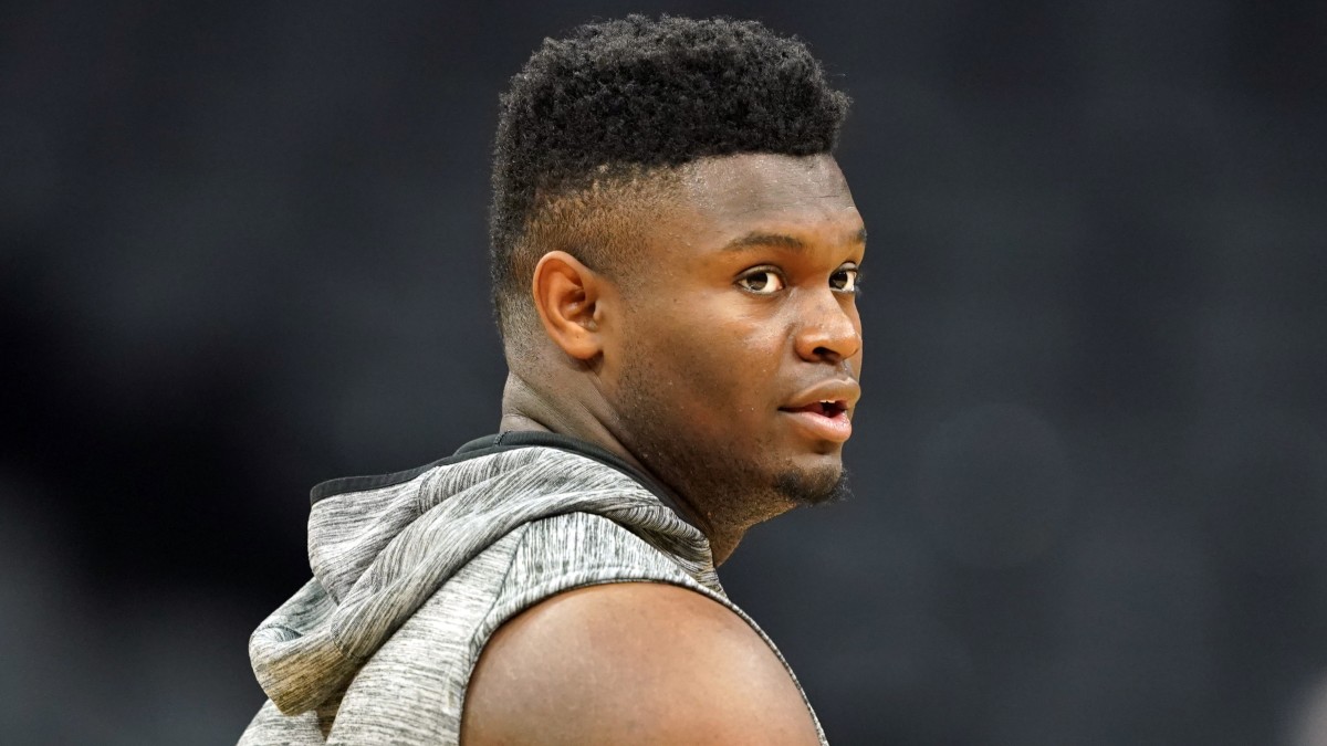 Zion Williamson hits the court during warmups but has yet to make his NBA debut.