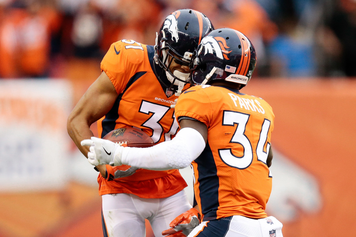 Denver Broncos strong safety Justin Simmons (31) celebrates with safety Will Parks (34) after an interception against the Oakland Raiders in the fourth quarter at Sports Authority Field at Mile High.