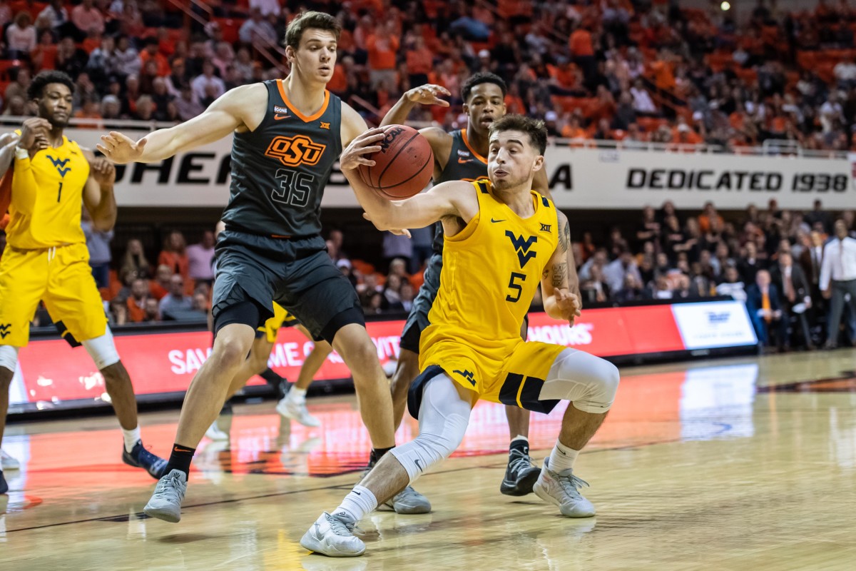 West Virginia Mountaineers guard Jordan McCabe (5) dribbles while defended by Oklahoma State Cowboys forward Hidde Roessink (35) during the second half at Gallagher-Iba Arena.