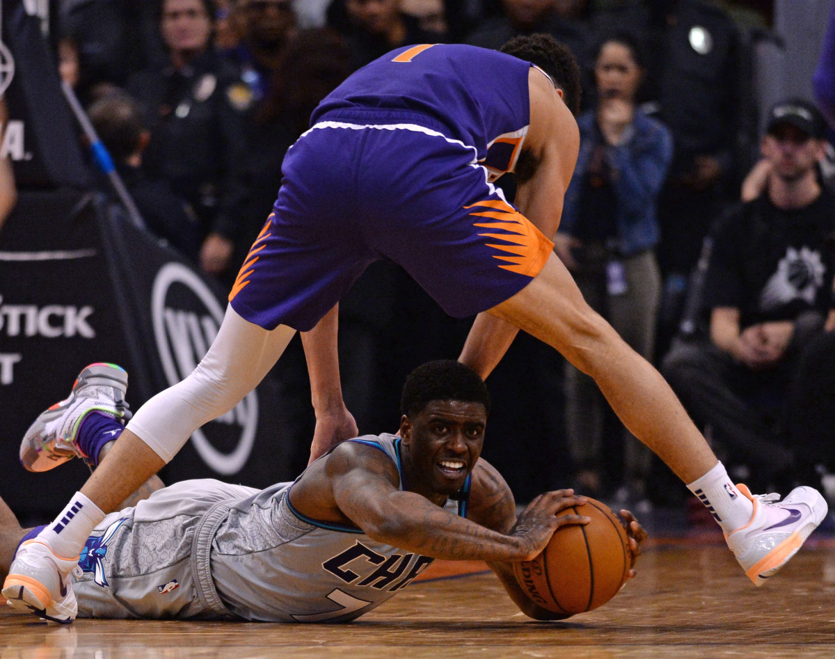 Jan 12, 2020; Phoenix, Arizona, USA; Charlotte Hornets guard Dwayne Bacon (7) attempts to move the ball by Phoenix Suns guard Devin Booker (1) during the second half at Talking Stick Resort Arena. Mandatory Credit: Joe Camporeale-USA TODAY Sports