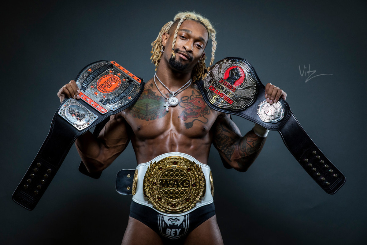 Wrestler Chris Bey with his championship belts