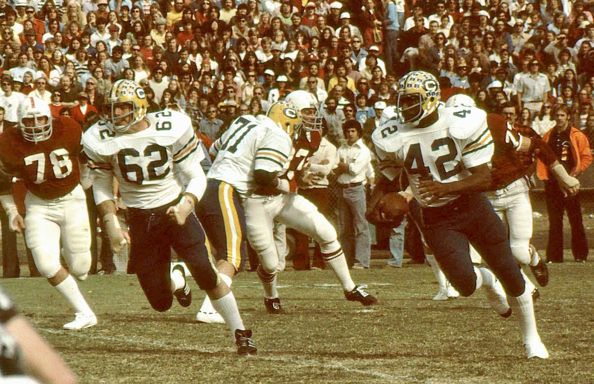 Pat Micco (62) leads blocking for Cal star back Chuck Muncie in 1975