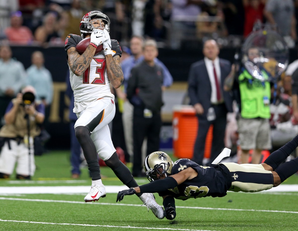 Sep 9, 2018; New Orleans, LA, USA; Tampa Bay Buccaneers wide receiver Mike Evans (13) hauls in a pass for a 50-yard touchdown while defended by New Orleans Saints cornerback Marshon Lattimore (23) in the third quarter at the Mercedes-Benz Superdome. The Bucs won, 48-40. Mandatory Credit: Chuck Cook-USA TODAY Sports