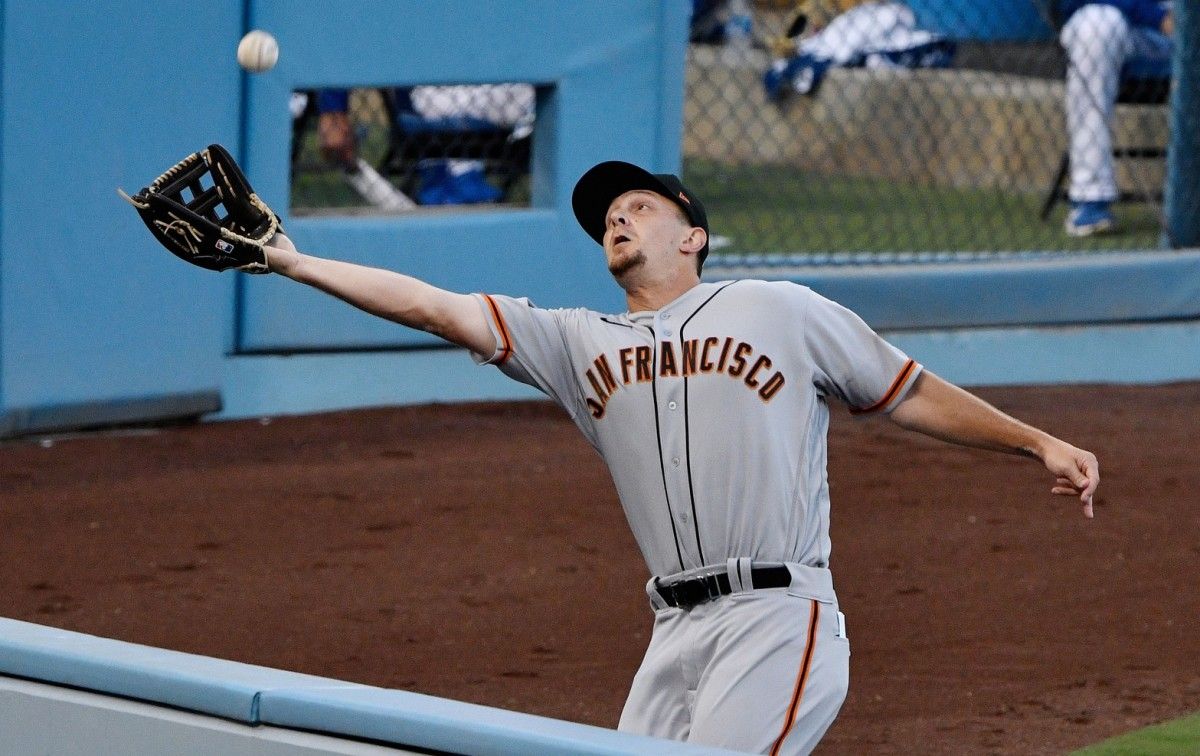San Francisco Giants left fielder Alex Dickerson (12) makes a running catch on a fly ball off the bat of Los Angeles Dodgers center fielder Cody Bellinger in the first inning at Dodger Stadium. (Robert Hanashiro-USA TODAY Sports)