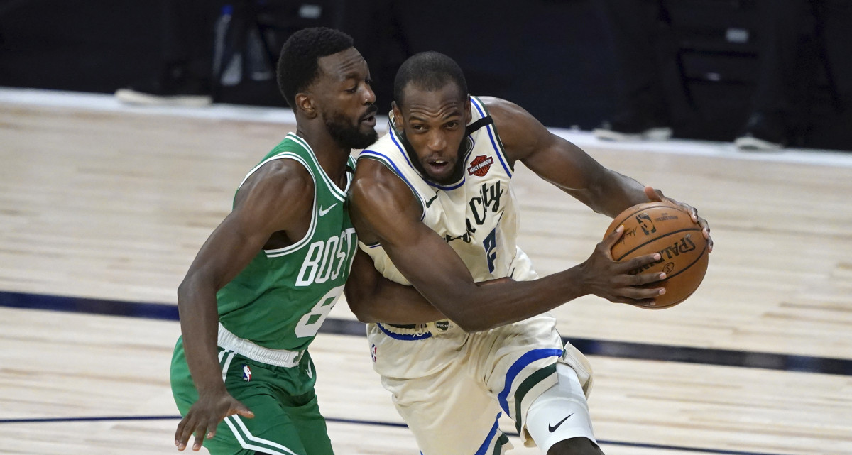 Milwaukee Bucks' Khris Middleton, right, heads to the basket past Boston Celtics' Kemba Walker during the first half of an NBA basketball game Friday, July 31, 2020, in Lake Buena Vista, Fla.