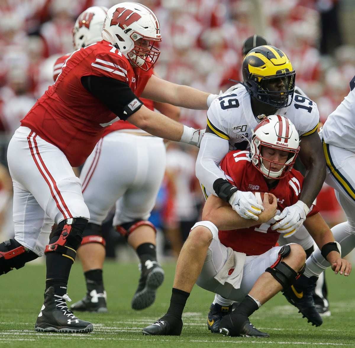 Michigan Wolverines defensive lineman Kwity Paye (19) sacks Wisconsin Badgers quarterback Jack Coan (17).