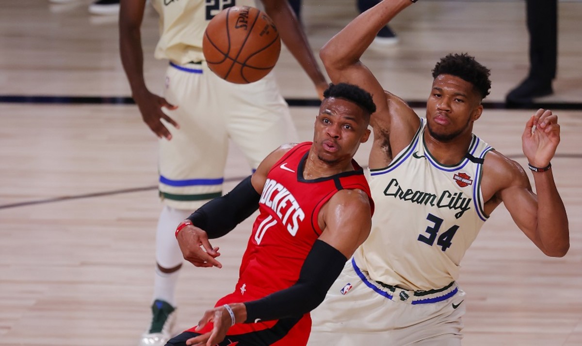 Houston Rockets guard Russell Westbrook passes under pressure from Milwaukee Bucks forward Giannis Antetokounmpo at The Arena at ESPN Wide World Of Sports Complex in Lake Buena Vista, Fla.