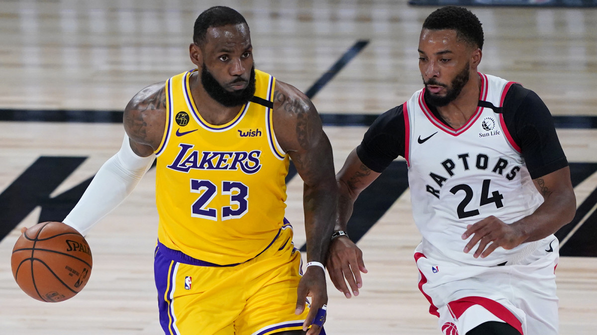 Los Angeles Lakers forward LeBron James handles the ball against Toronto Raptors guard Norman Powell