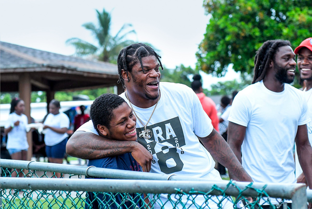 Lamar Jackson poses for a photo with a kid at McNair Park