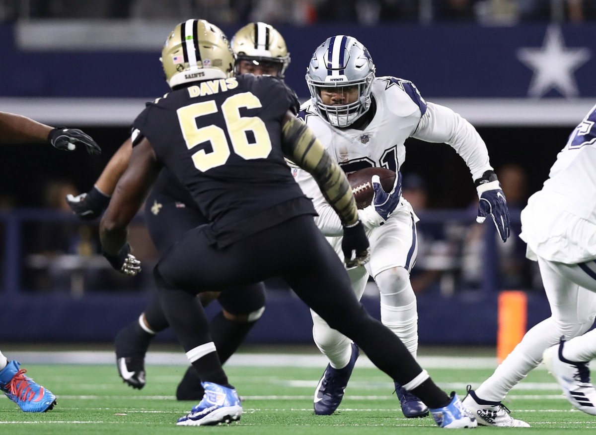 Nov 29, 2018; Arlington, TX, USA; Dallas Cowboys running back Ezekiel Elliott (21) runs with the ball against New Orleans Saints linebacker Demario Davis (56) in the first quarter at AT&T Stadium. Mandatory Credit: Matthew Emmons-USA TODAY