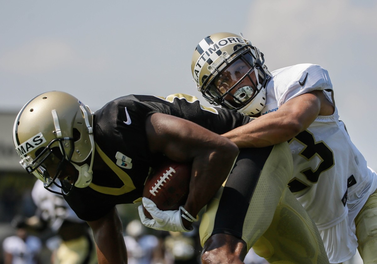 Jul 28, 2018; Metairie, LA, USA; New Orleans Saints cornerback Marshon Lattimore (23) tackles wide receiver Michael Thomas (13) during training camp at New Orleans Saints Training Facility. Mandatory Credit: Derick E. Hingle-USA TODAY Sports