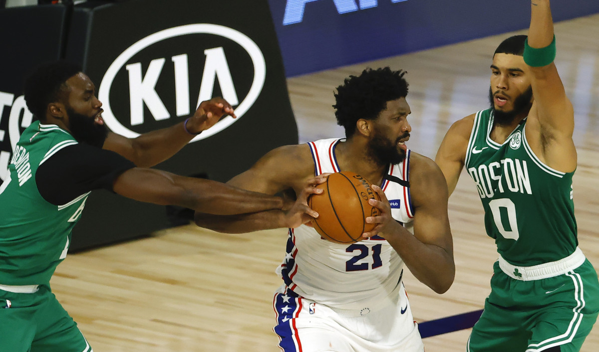 Joel Embiid #21 of the Philadelphia 76ers is pressured by Jaylen Brown #7 and Jayson Tatum #0 of the Boston Celtics during the second quarter in game two of the first round of the 2020 NBA Playoffs