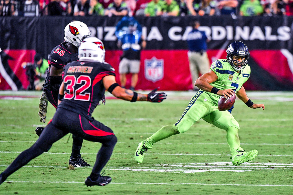 Russell Wilson spins as he tries to evade Cardinals defenders Chandler Jones and Tyrann Mathieu