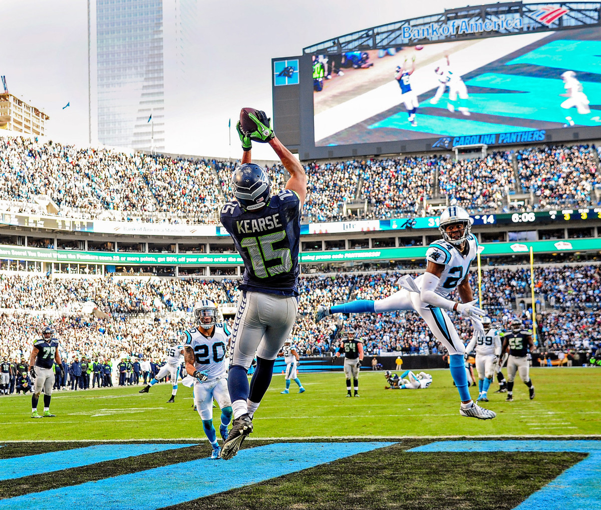 Jermaine Kearse catches a touchdown pass from Russell Wilson (on the ground in the background) as Panthers cornerback Josh Norman looks back.