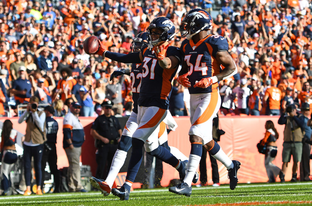 Broncos safety Justin Simmons celebrates an interception with two teammates