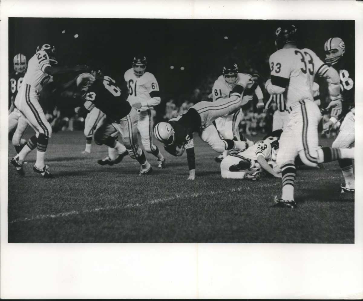 Bill George (61) and Doug Atkins (81) pursue Packers halfback Paul Hornung.