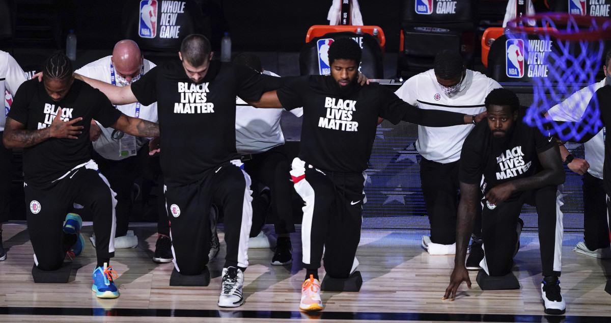 Los Angeles Clippers players kneel in honor of the Black Lives Matter movement during the playing of the national anthem prior to an NBA basketball game