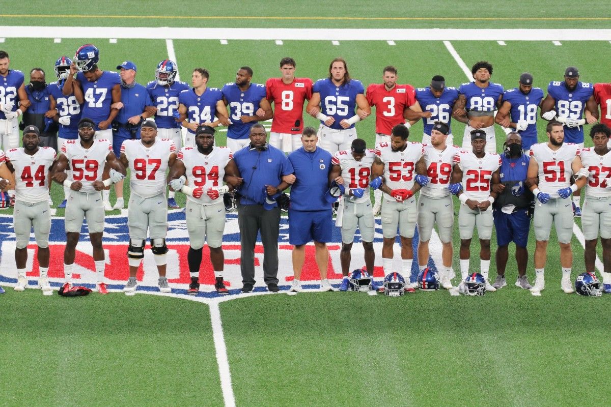 Head coach Joe Judge and his team at midfield linking arms in a call for social justice before the New York Giants play an inter-squad game, the Blue White scrimmage at MetLife Stadium on