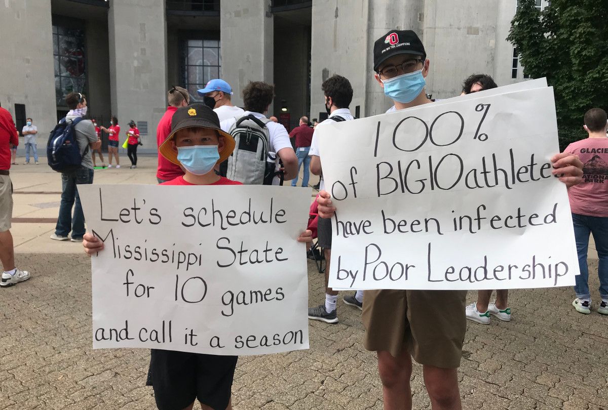 Fans hold signs at Big Ten protest