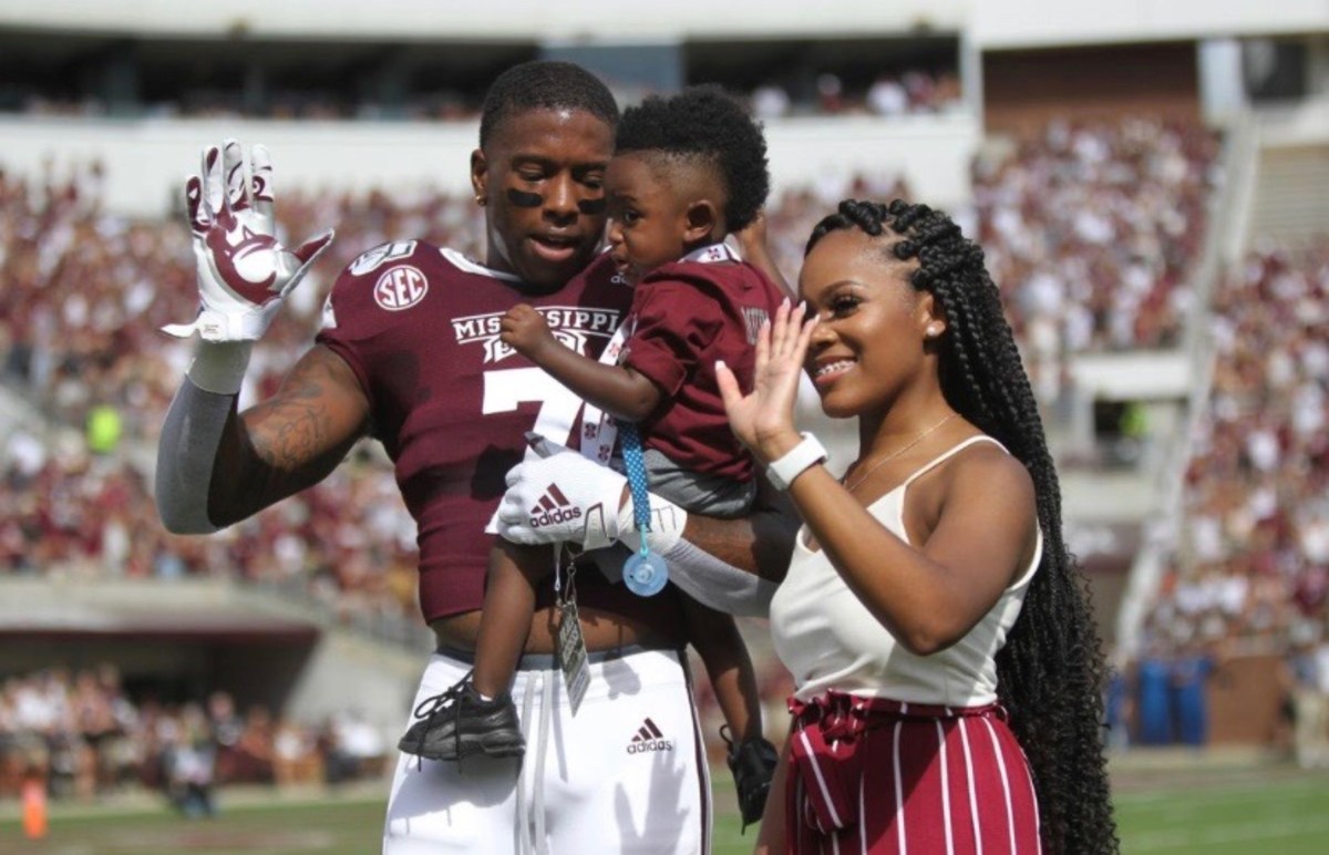 Marcus Murphy holds his son, Mason, and stands alongside Mason's mother, Alicia Cherry, in an on-field presentation last season. (Photo submitted by Alicia Cherry)